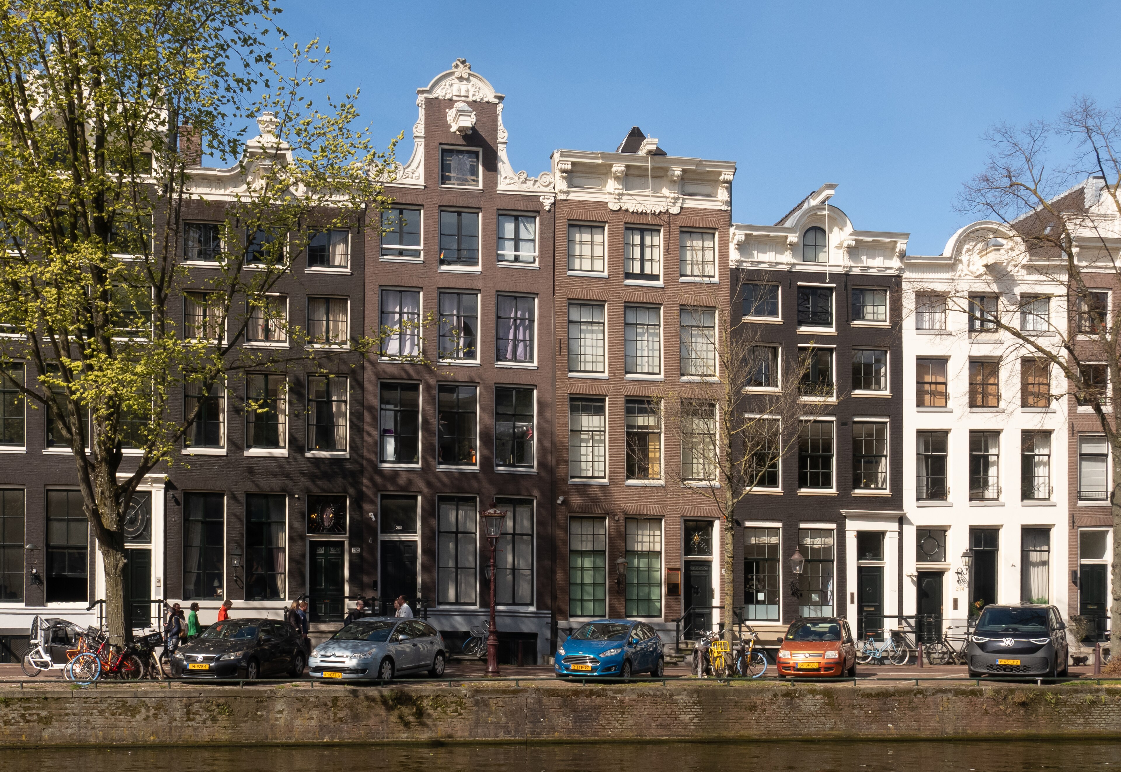 Hoge grachtengevels die weerspiegelen in het water